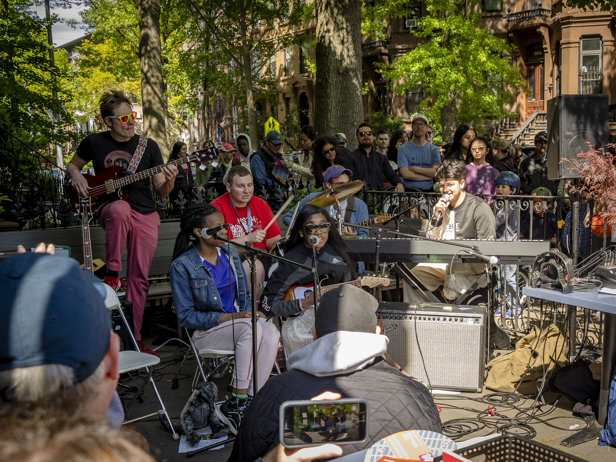 The DaFunkies performing on a street under green trees