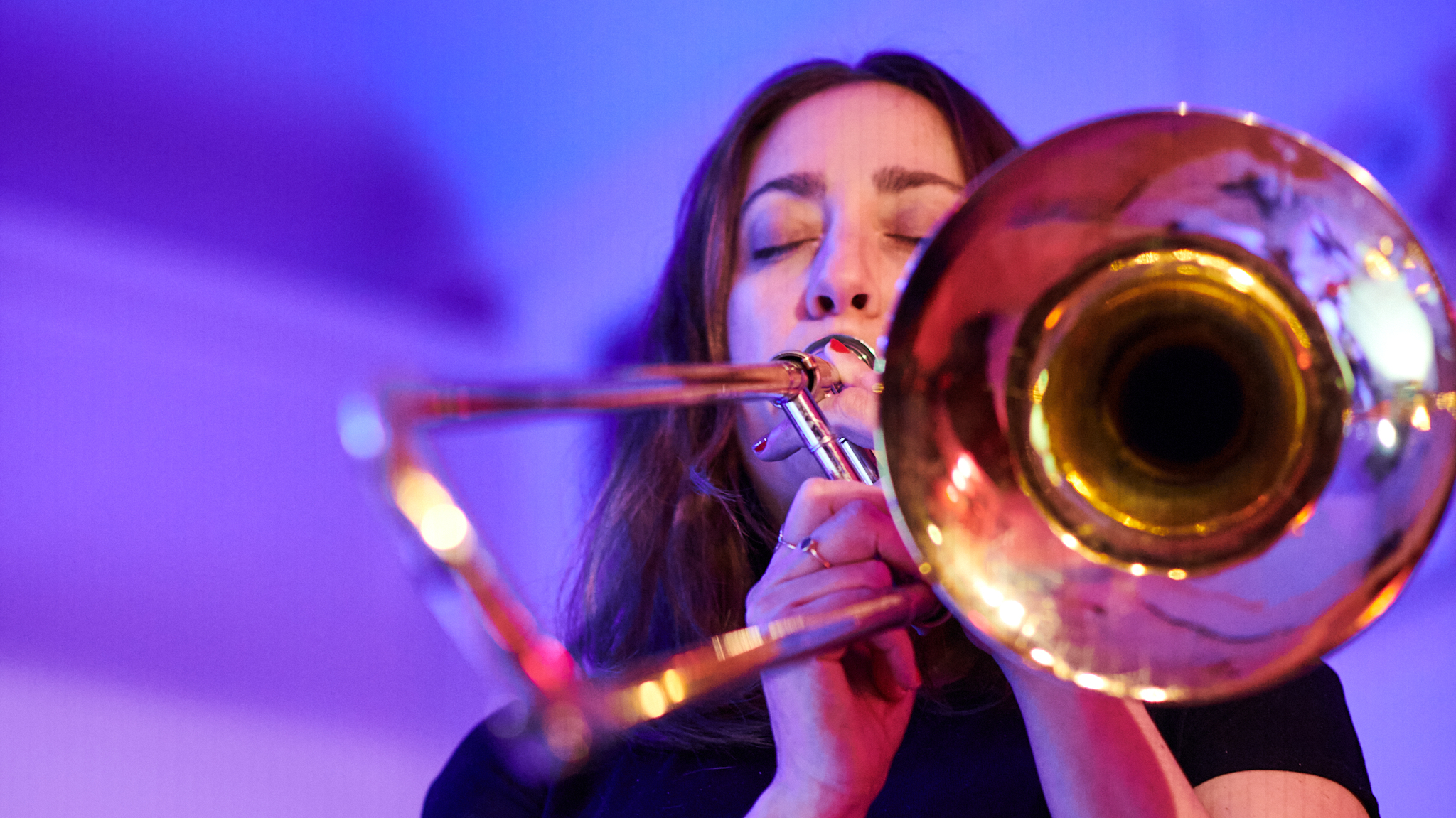 An Adult Jazz Ensemble member playing the trombone during a recital