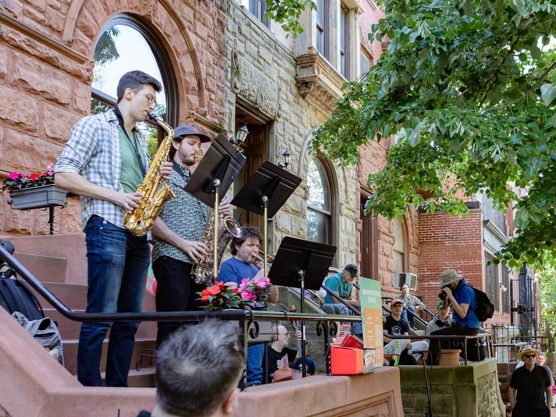 Adult jazz ensemble members performing outside at Open Stages 2025