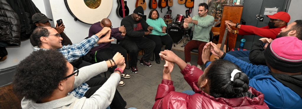 BKCM Music Therapy adult day hab group doing an exercise together