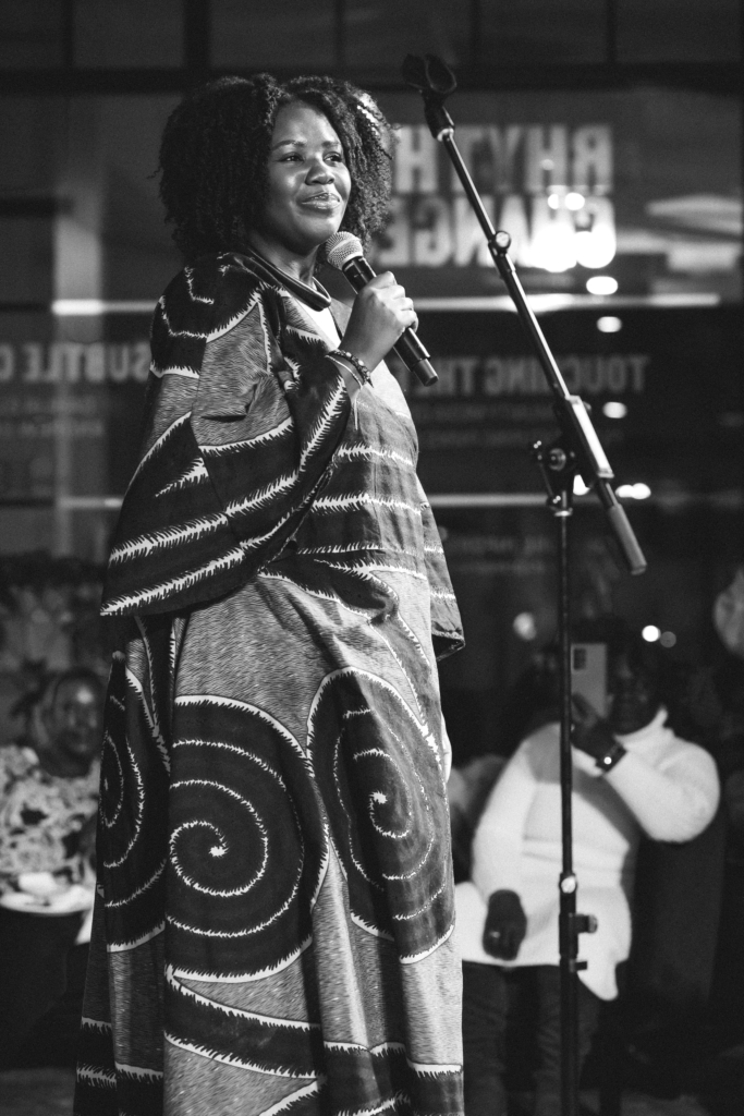 The musician Merikara holding a microphone on stage